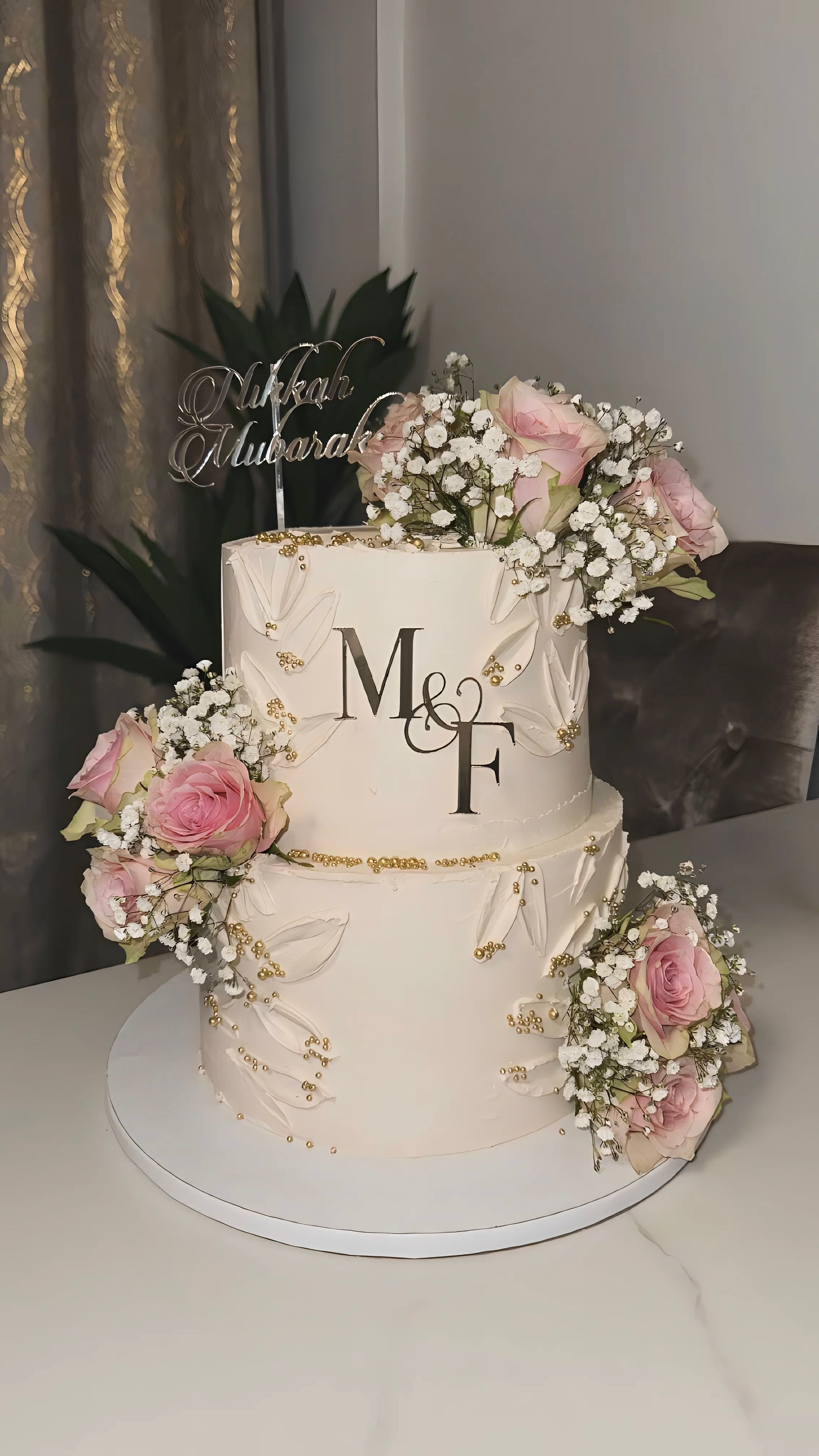 Two-tier nikkah cake with pink roses, baby’s breath, and gold details